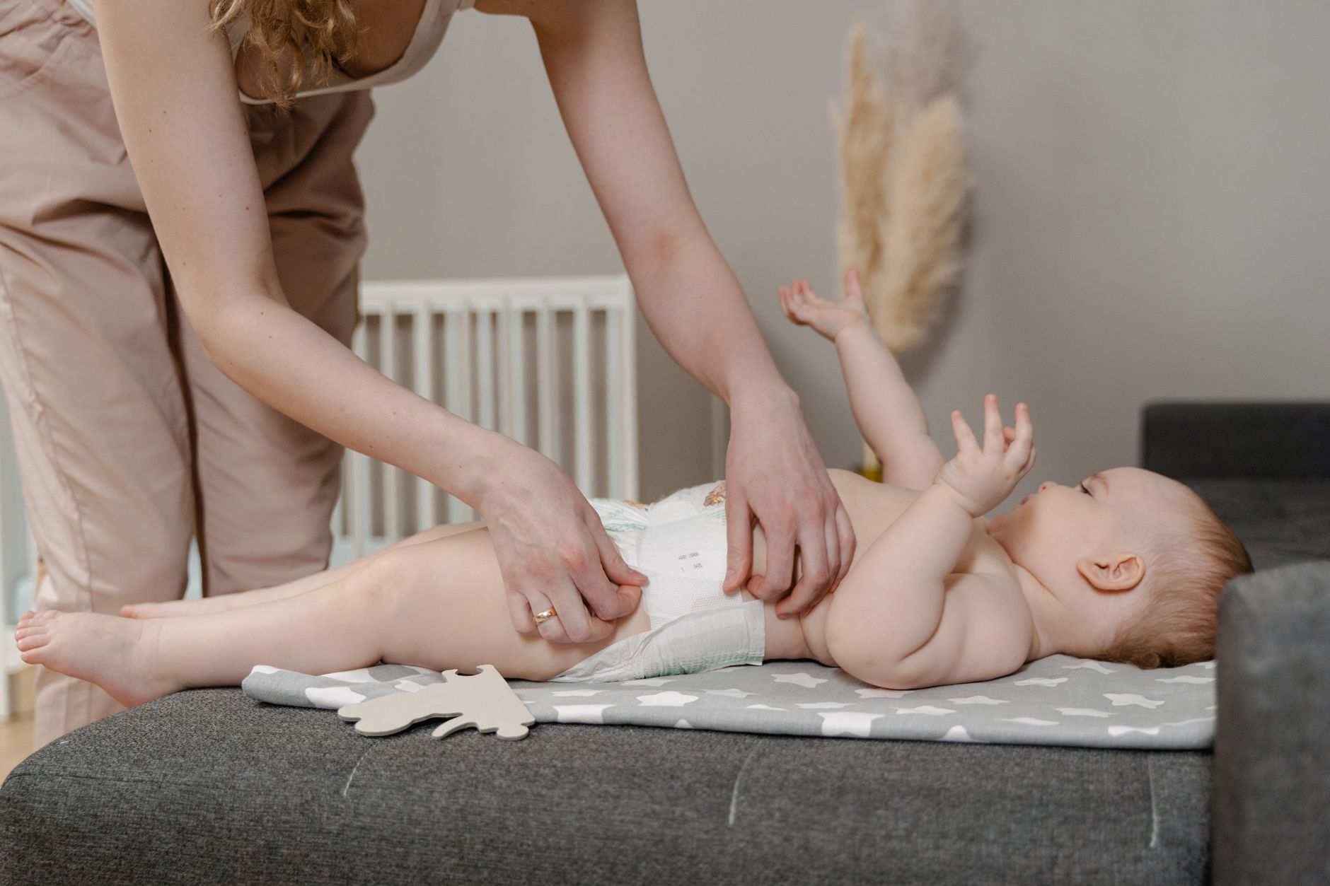 Parent changeant la couche d'un bébé sur un matelas à langer