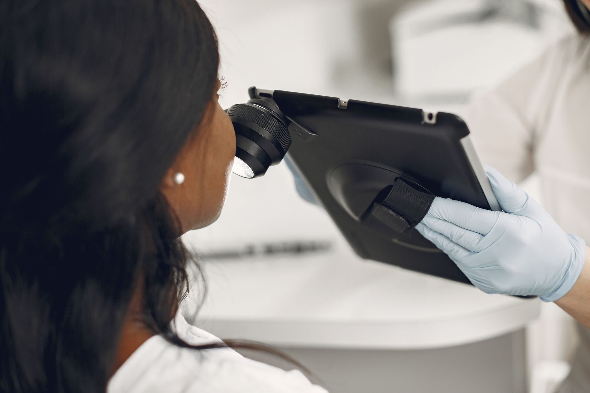 Dermatologue examinant la peau d’une patiente avec un dermatoscope numérique