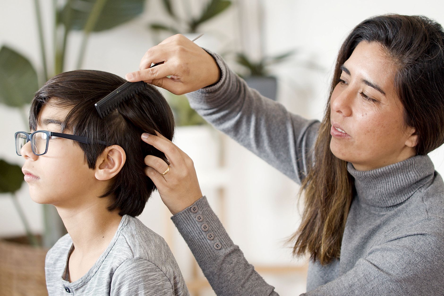 Mère examinant les cheveux de son fils avec un peigne fin